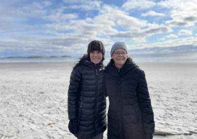 Helene Downs and her daughter, wearing winter coats and hats, on a beach.