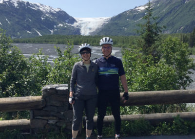 Celia Lankford posed with her husband in front of a scenic mountain view during a bike ride.