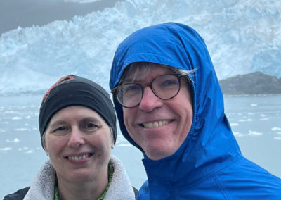 Celia Lankford and her husband smiling together in front of a glacier.
