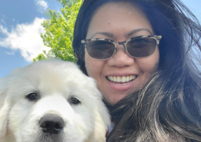 Fay Paurillo smiling in a selfie with her dog outside.