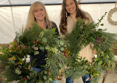 Jennifer Lehman and a friend posed together, holding up wreaths.